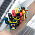 A row of vibrant Ignition Pocket Lighters - Nature Series by MK Lighter Company with playful, cartoon-like designs sits on a ledge, the blurred background highlighting the colorful refillable butane lighters in the foreground.