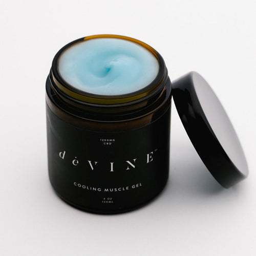 An open jar of deVINE Cooling Muscle Gel by DeVINE Wellness, filled with light blue gel, sits on a white background. Its sleek black label showcases 1200mg CBD for effective pain relief in this premium muscle gel.