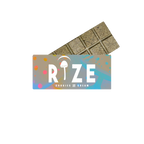 The Rize 5G Mushroom Chocolate Bar, partially wrapped in colorful packaging with a white mushroom above the “I” in RIZE, offers a consistent magic mushroom chocolate experience in every bite.